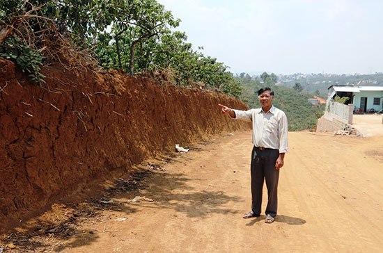 Ông Võ Văn Minh bên phần đất hiến để mở đường