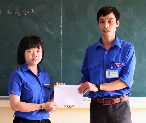 Thầy Đinh Xuân Hậu trao tiền hỗ trợ giúp học sinh mình nhận đỡ đầu