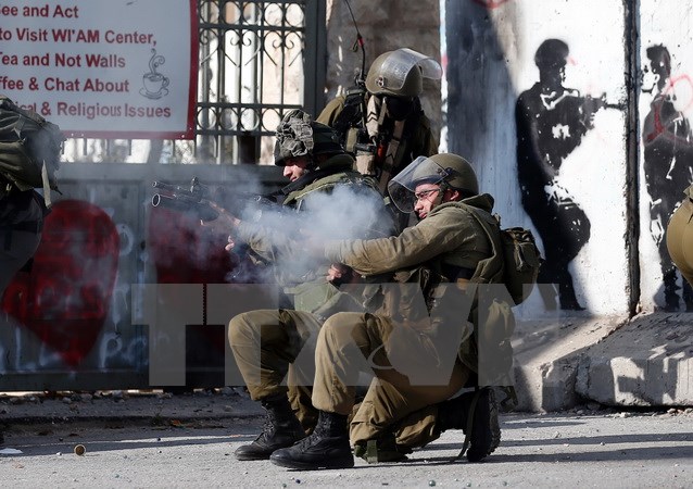 Binh sỹ Israel bắn đạn cao su và hơi cay vào người biểu tình bạo động Palestine ở thành phố Bethlehem, Khu Bờ Tây ngày 18/12/2015. (Nguồn: AFP/TTXVN)