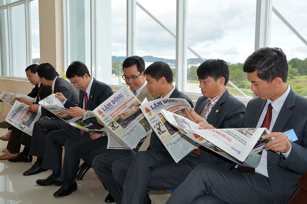 Các đại biểu đọc Báo Lâm Đồng bên lề Đại hội Đảng bộ tỉnh Lâm Đồng lần thứ X - Ảnh: VĂN BÁU