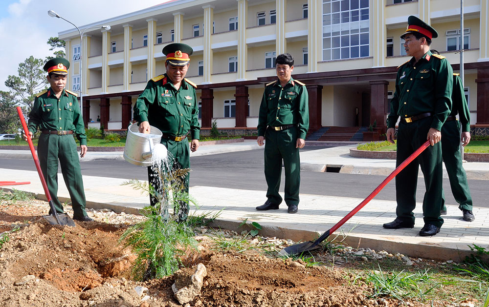 Phó Chính ủy Học viện, TS Đậu Văn Nậm (người cầm xoa) tham gia trồng cây
