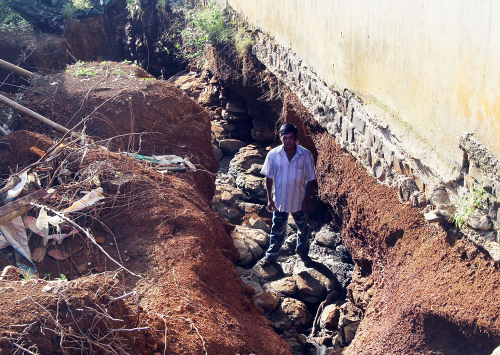 Đất và móng nhà của ông Huỳnh Văn Dũng bị nước cống từ Quốc lộ 20 khoét sâu gần 3 mét