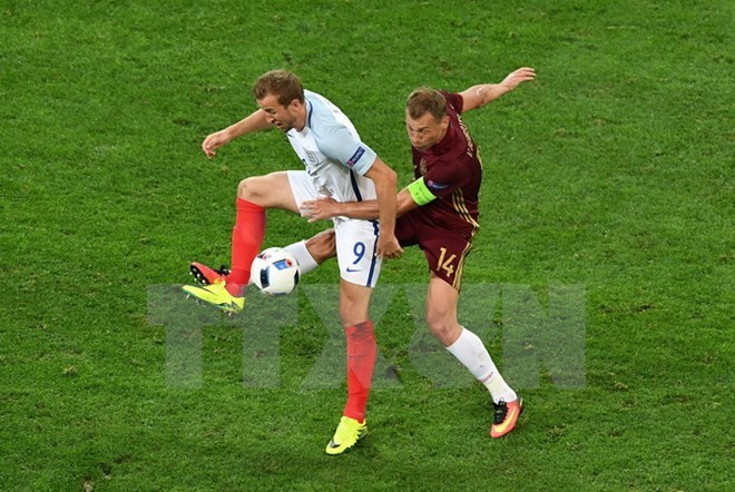 Tiền đạo Harry Kane (trái) đội tuyển Anh tranh bóng quyết liệt với hậu vệ Vasily Berezutskiy (đội tuyển Nga). (Nguồn: AFP/TTXVN)