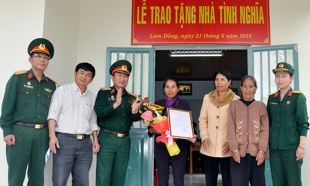 Thiếu tướng Lê Anh Thơ trao Quyết định tặng nhà tình nghĩa cho bà Kơ Đơng K Thu (ở giữa)