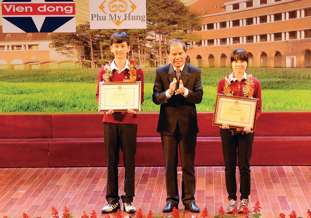Bí thư Tỉnh ủy Nguyễn Xuân Tiến trao Bằng khen của Bộ GD&ĐT cho 2 học sinh đoạt giải Ba tại Hội thi KHKT quốc tế. Ảnh: VĂN BÁU