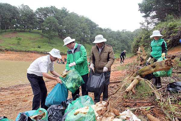 Phó Chủ tịch UBND tỉnh Phạm S (đứng giữa) cùng tham gia thu gom rác thải nông nghiệp