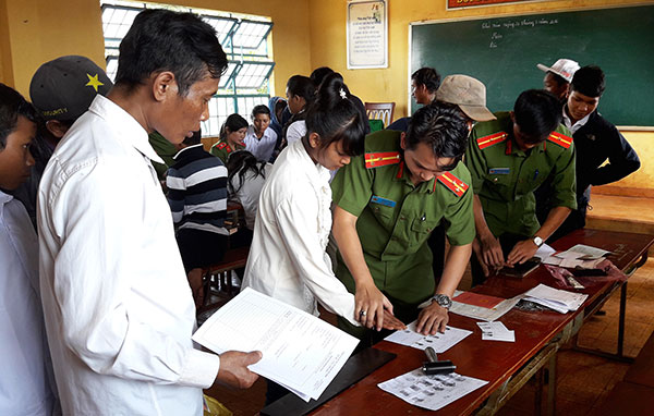 Cán bộ Công an huyện làm thủ tục cấp giấy chứng minh nhân dân cho bà con thôn Hang Hớt