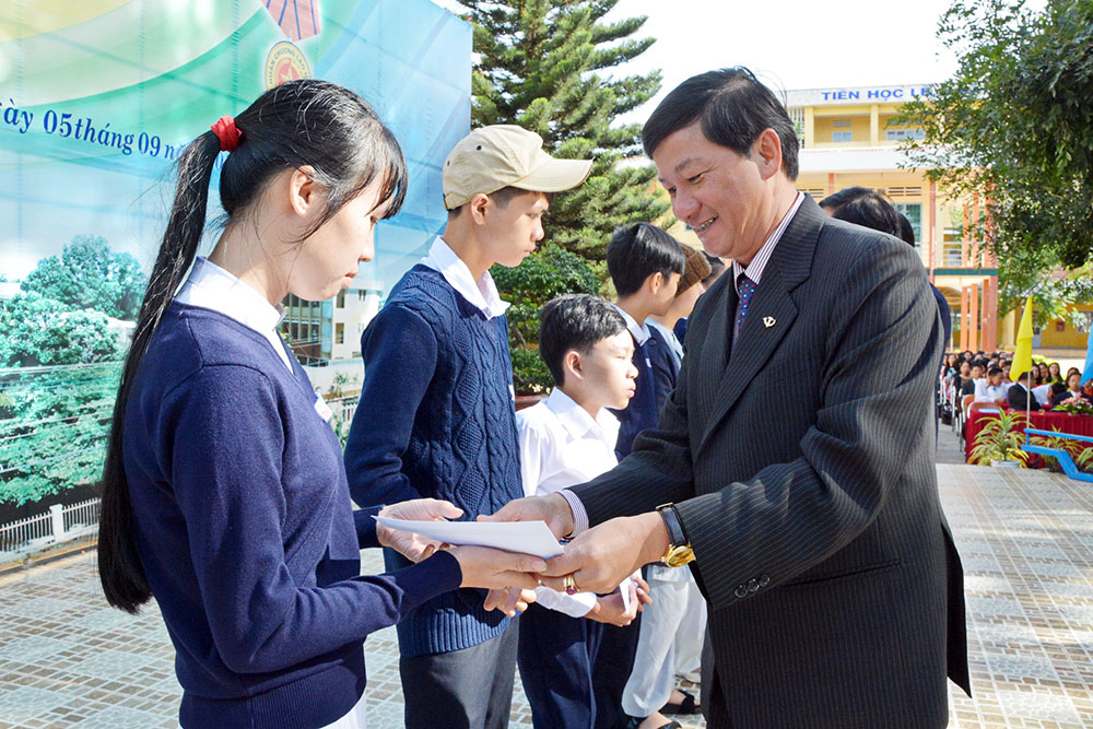 Đồng chí Trần Đức Quận trao học bổng cho học sinh nghèo hiếu học. Ảnh: Văn Báu