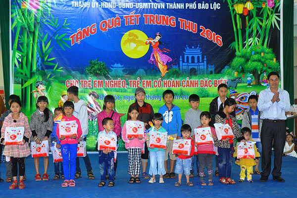 Ông Nghiêm Xuân Đức, Phó Chủ tịch UBND TP Bảo Lộc (bìa phải) trao quà Trung thu cho các cháu học sinh nghèo