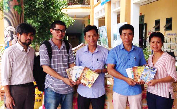 Anh Nguyễn Quang Thạch thứ hai từ trái qua, trao tặng sách tại một trường học (Hình do nhân vật cung cấp)