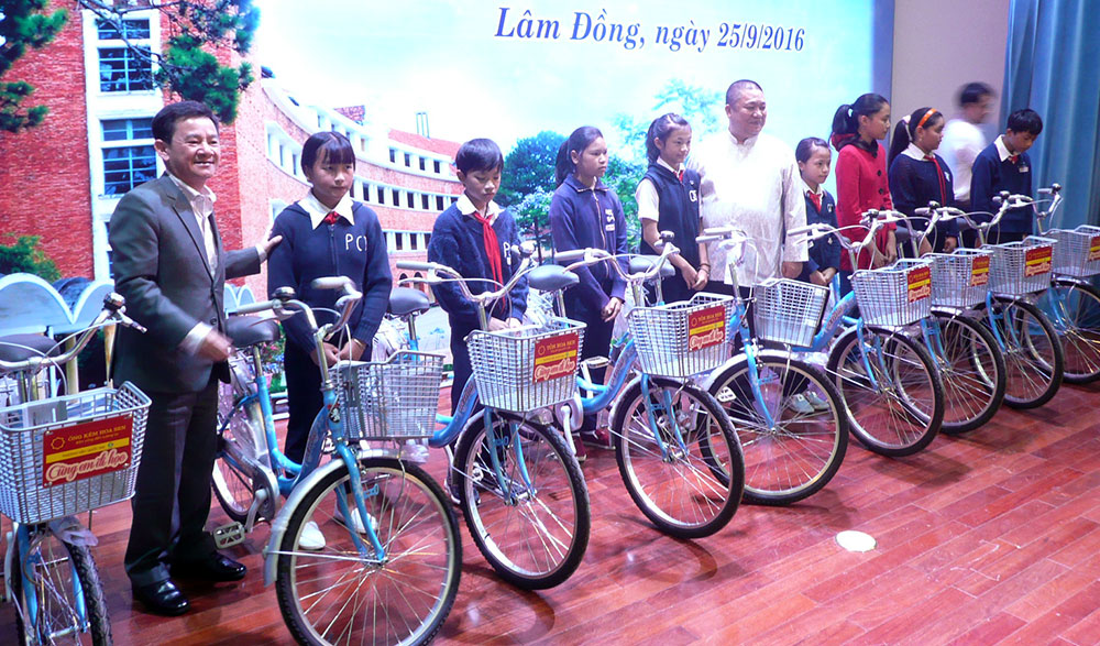Phó Chủ tịch UBND tỉnh Phan Văn Đa và ông Lê Phước Vũ, Chủ tịch Tập đoàn Hoa Sen trao tặng xe đạp cho học sinh tại buổi lễ