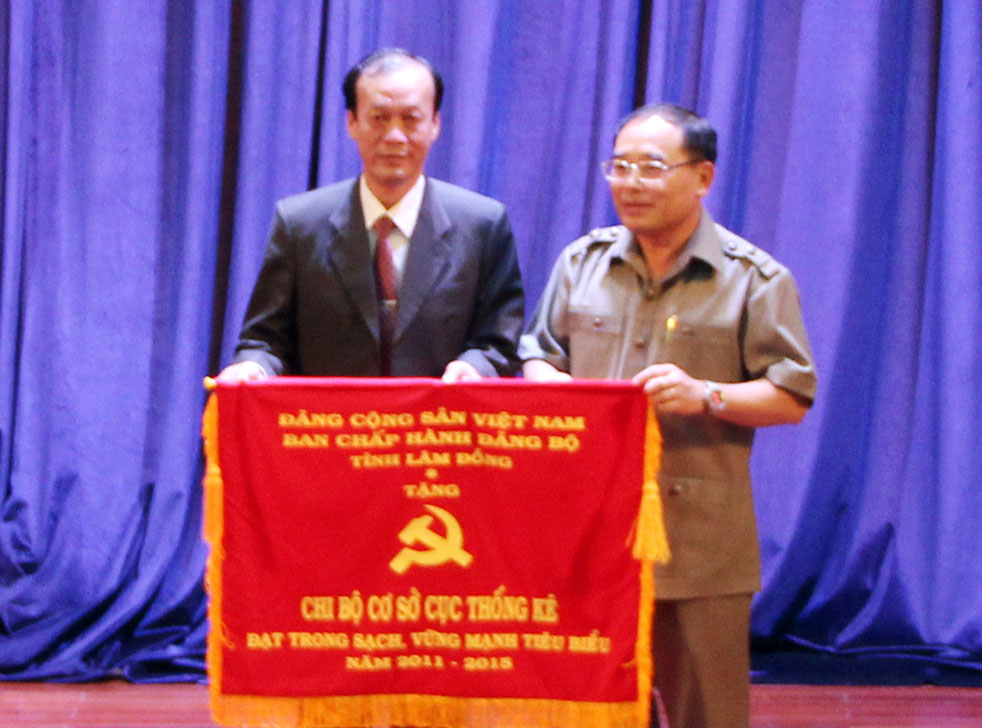 Đồng chí Vũ Kim Sinh - Bí thư Đảng ủy Khối các cơ quan tỉnh trao cờ của Ban Thường vụ tỉnh ủy cho Chi bộ Cục thống kê Lâm Đồng