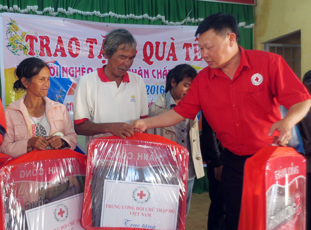 Ông Đỗ Hoàng Tuấn - Chủ tịch Hội Chữ thập đỏ tỉnh trao quà cho người nghèo. Ảnh: T.Linh
