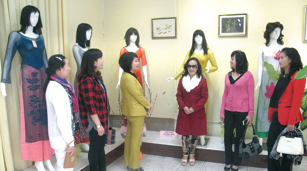 Chị Võ Thị Sơn (đứng thứ ba từ phải sang) cùng lãnh đạo Hội LHPN Đà Lạt và nhóm thợ trong gian trưng bày các sản phẩm áo dài móc bằng sợi. Ảnh: D.Hiền