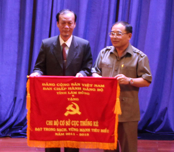 Đồng chí Vũ Kim Sinh -TUV, Bí thư Đảng ủy Khối CCQ tỉnh trao cờ của BTV Tỉnh ủy cho Chi bộ Cục Thống kê Lâm Đồng. Ảnh: H.MY