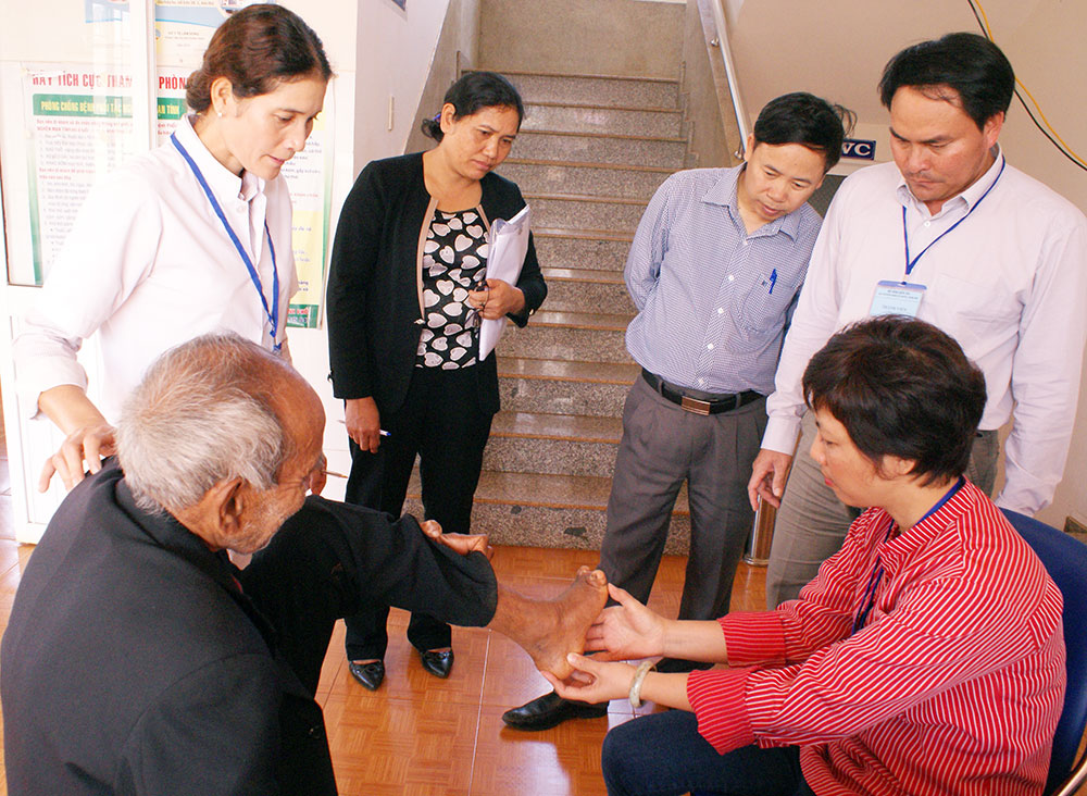Ths-BS Lê Thị Mai - Bệnh viện Da liễu Trung ương đang kiểm tra tình hình chăm sóc khuyết tật và phục hồi chức năng của bệnh nhân phong. Ảnh: A.Nhiên