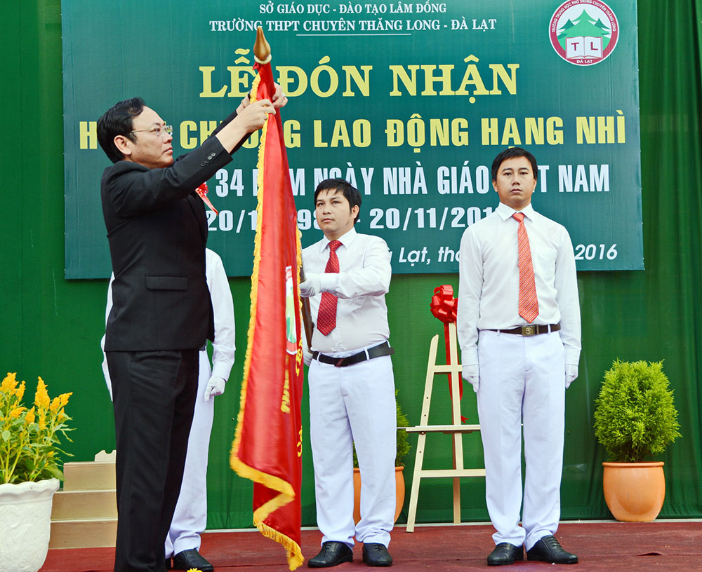 Đồng chí Nguyễn Văn Yên gắn Huân chương lên lá cờ truyền thống của nhà trường. Ảnh: V.Báu