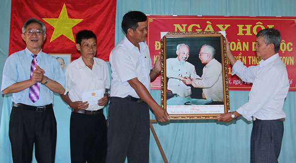 Đồng chí Phan Hoàng Anh – Phó Chủ tịch UBMTTQ Việt Nam tỉnh tặng ảnh chân dung Bác Hồ với Bác Tôn cho cán bộ và nhân dân thôn 2