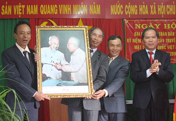 Bí thư Tỉnh ủy Nguyễn Xuân Tiến (bìa phải) trao tặng bức tranh Bác Hồ - Bác Tôn cho thôn Phát Chi, xã Trạm Hành, TP Đà Lạt. Ảnh: N.Thu