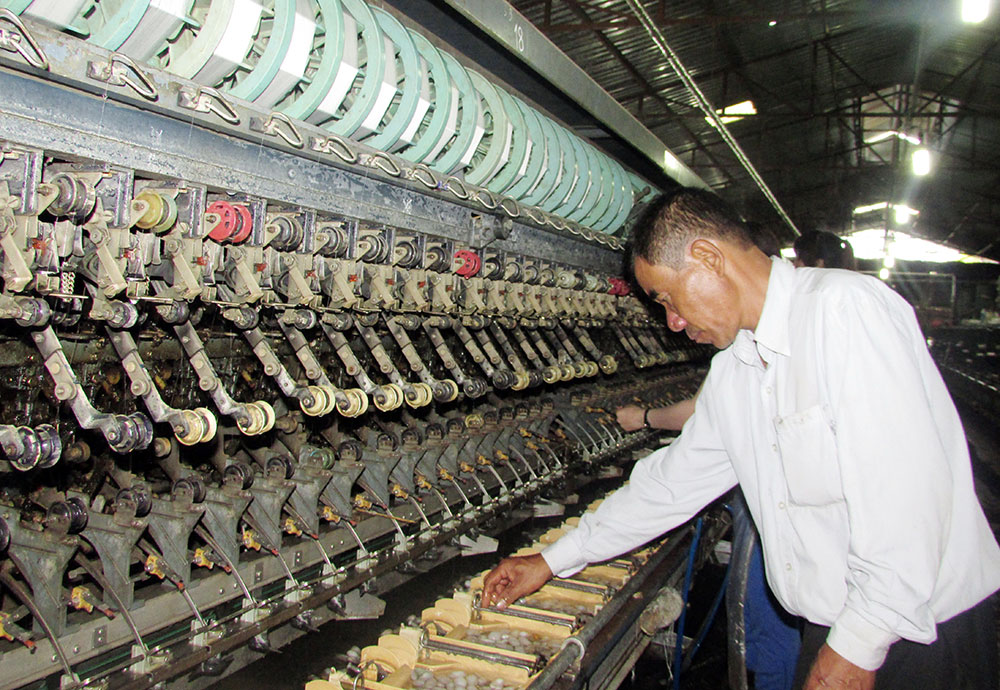 Chủ nhân Lê Sáu trong xưởng ươm tơ xuất khẩu tại xã Đinh Lạc, Di Linh. Ảnh: V.Việt