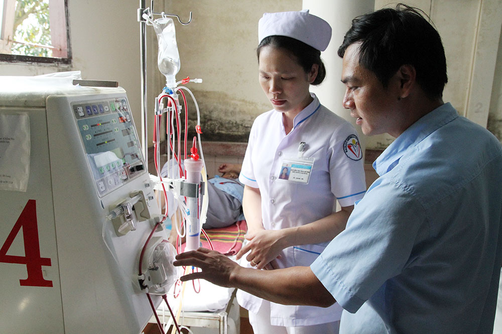 Nhân viên kỹ thuật và nữ điều dưỡng Nguyễn Thị Nga Hương kiểm tra một máy chạy thận. Ảnh: H.Sang