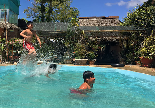 Lũ trẻ vô tư bơi lội ở bể bơi nhà bà giáo Nhung. Ảnh: N.Ngà