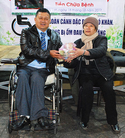 Ông Trần Mạnh Thu - Chủ tịch Hội Người khuyết tật TP Đà Lạt trao số tiền ủng hộ cho chị Tý