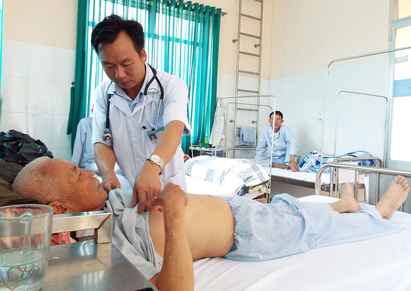 Bác sĩ CKI Nguyễn Văn Minh chăm sóc bệnh nhân như chính người thân của mình. Ảnh: Q.Uyển