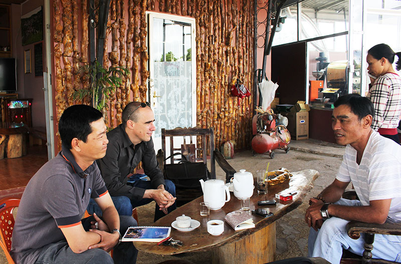 Anh Khanh (trái) giới thiệu quy trình sản xuất cà phê Cầu Đất cho du khách. Ảnh: H.Yên