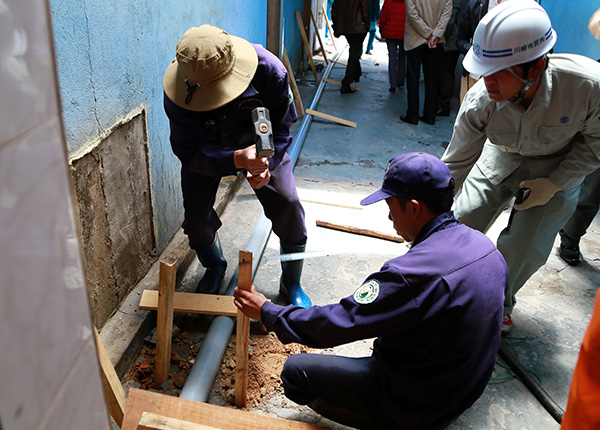 Công nhân Cấp thoát nước Lâm Đồng hỗ trợ các kỹ sư Công ty CP địa chất Kawasaki lắp đặt thiết bị quan trắc các vết nứt tại căn nhà 27C, đường Nguyễn Văn Trỗi