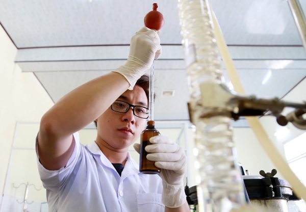 Sinh viên Nguyễn Ngọc Vinh, thành viên trong nhóm nghiên cứu đang chưng cất tinh dầu bưởi tại phòng thí nghiệm Khoa Sinh học, ĐH Đà Lạt sáng 21/5. Ảnh: C.Thành