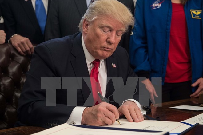 Tổng thống Mỹ Donald Trump ký ban hành một đạo luật tại Nhà Trắng ngày 21/3. (Nguồn: AFP/TTXVN)