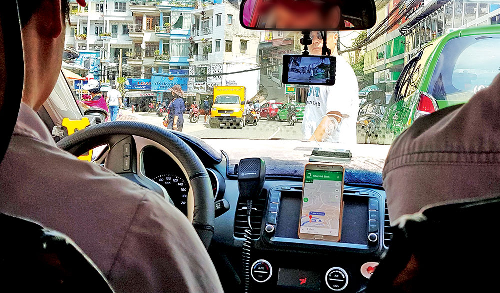 Mặc dù chưa được cơ quan chức năng cho phép chạy trên địa bàn nhưng với nhiều ưu điểm, taxi công nghệ hiện được nhiều khách hàng chọn dùng. Trong ảnh: Một tài xế của hãng taxi truyền thống cài phần mềm Grab về chạy tại Đà Lạt. Ảnh: C.Phong