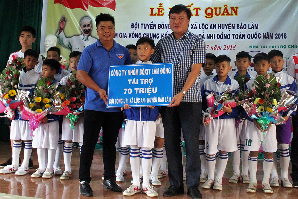Anh Vũ Quốc Huy (bìa trái) nhận quà của nhà tài trợ cho Đội U11 Lộc An. Ảnh: K.P