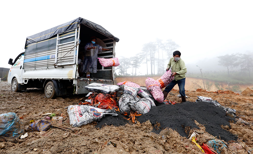 Lực lượng chức năng tiến hành tiêu hủy hàng giả, kém chất lượng tại bãi rác Cam Ly năm 2018. Ảnh: C.Phong