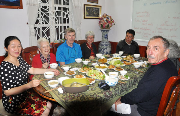Ông bà Gerard và Linda Zschoche (thứ ba, thứ tư từ trái qua) cùng các thành viên trong nhóm du lịch của mình trong bữa cơm tối tại nhà một người dân ở Đà Lạt