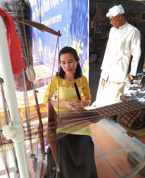 Nghệ nhân dệt vải Chăm dưới chân tháp Po Klon Garai. Ảnh: D.Quỳnh 