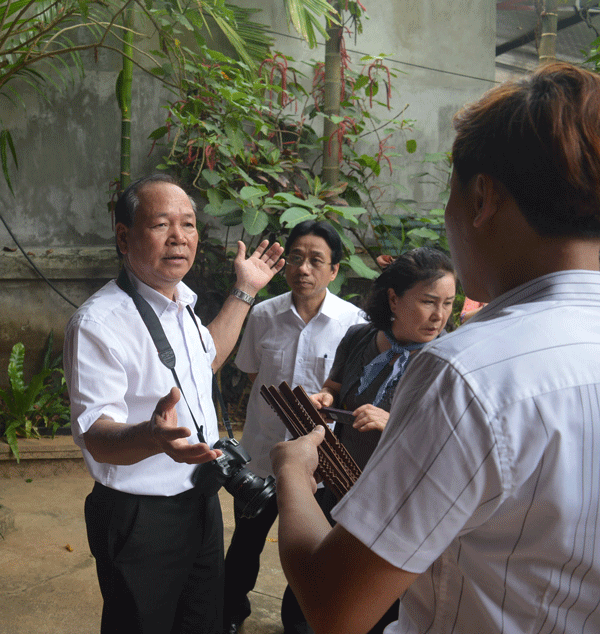 Chủ nhân Bảo tàng Bùi Thanh Bình (mang máy ảnh) trò chuyện với du khách