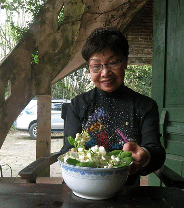 Nhà thơ Phan Thị Thanh Nhàn với hoa bưởi ở trang trại của NSƯT Chiều Xuân - chương trình VTV2 năm 2019 (ảnh tác giả cung cấp).