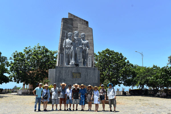 Đoàn cán bộ, phóng viên Báo Lâm Đồng bên tượng đài Đội Hoàng Sa kiêm quản Bắc Hải phủ xanh cây bàng vuông ở huyện đảo Lý Sơn