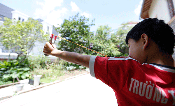 Một học sinh dùng ná bắn chim trong nội ô thành phố Đà Lạt. Ảnh: C.Phong