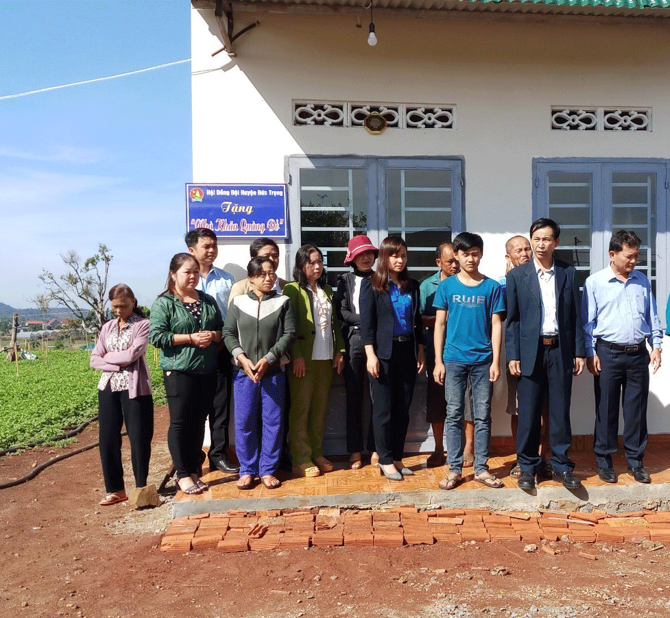 Em Nông Viết Quang (thứ 3 từ phải qua) chụp hình lưu niệm cùng đại diện Huyện đoàn, lãnh đạo thị trấn Liên Nghĩa và Ban Giám hiệu Trường Nguyễn Trãi trước ngôi nhà “Khăn quàng đỏ” vừa được trao tặng