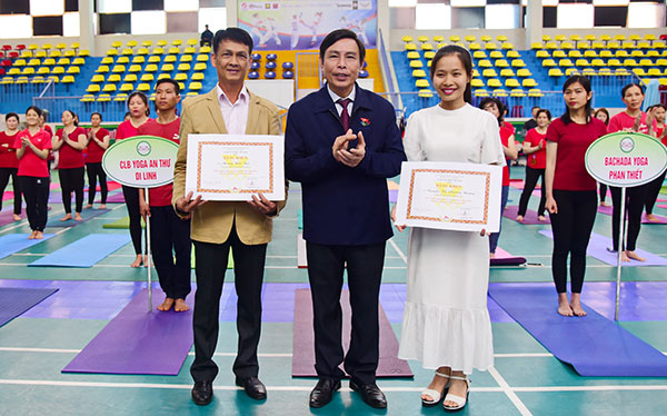 Ông Vũ Trọng Lợi, Chủ tịch Liên đoàn Yoga Việt Nam trao bằng khen cho các CLN tham dự đồng diễn 
