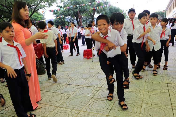 Đôi bạn cùng tiến tại lớp 6A3, Trường THCS thị trấnMađaguôi (trong ảnh - em Nguyễn Văn Đức cõng em K’Tuyệt bị khuyết tật đến dự ngày tự trường năm học mới)