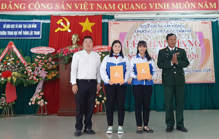 Ông Nguyễn Đình Hiệu (bên trái) trao học bổng cho học sinh trường THPT Lộc Thanh – Bảo Lộc