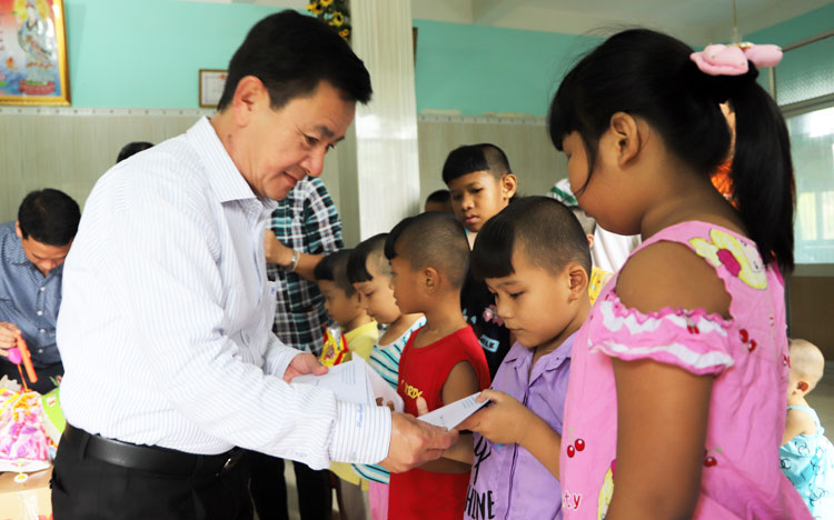 Đồng chí Phan Văn Đa trao học bổng cho trẻ em tại Cơ sở Bảo trợ xã hội Mađaguôi (huyện Đạ Huoai)
