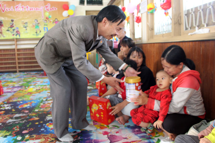 Đồng chí Trương Thành Được trao quà cho các em nhỏ Làng Hòa Bình