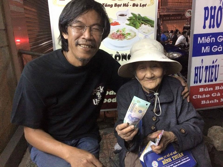 Nhạc sĩ Lê Huy Cầm trao tiền giúp đỡ cụ bà lang thang bán vé số trên đường Tăng Bạt Hổ - Đà Lạt. Ảnh: A.Nhiên