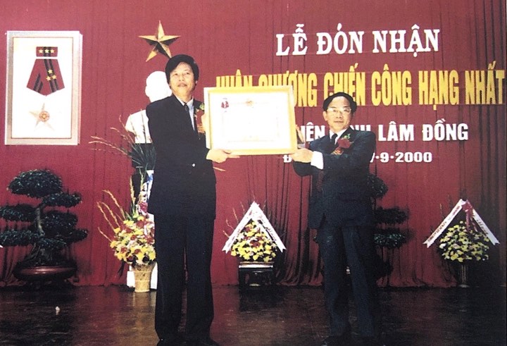 Đồng chí Nguyễn Huy Ninh (bên trái) thay mặt Bưu điện Lâm Đồng nhận Huân chương Chiến công hạng Nhất.