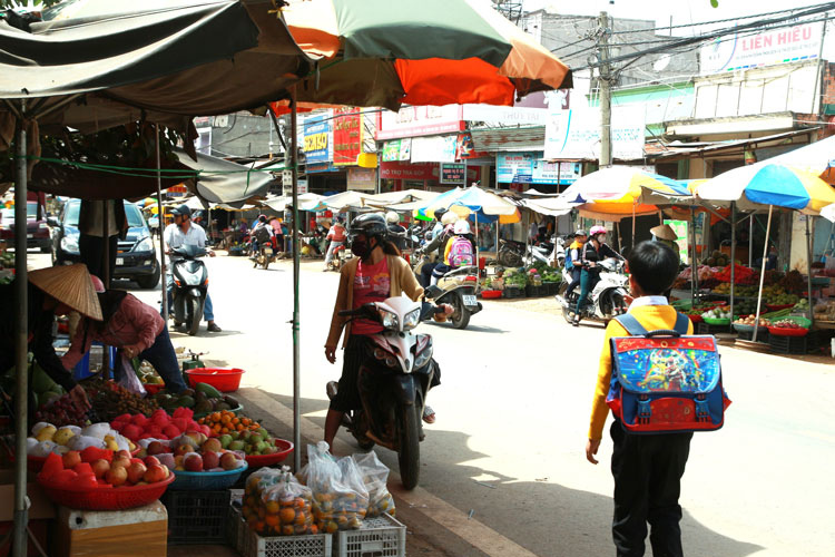 Người dân có thói quen dừng mua hàng ở những quầy, sạp ven đường (trong ảnh là chợ Thăng Long ở thị trấn Nam Ban) ảnh hưởng đến giao thông, nhất là vào giờ cao điểm